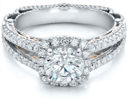 A double-band diamond ring featuring a large round-cut center stone surrounded by a halo, with smaller diamonds along the bands. The ring is set in a silver-toned metal with rose gold accents visible on the inner band, photographed on a clean white background.