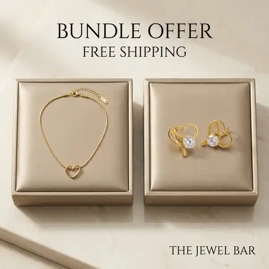 A jewelry bundle offer from The Jewel Bar featuring a gold heart-link bracelet and matching gold heart stud earrings with clear gemstones, presented in two beige satin boxes on a light marble background with 'BUNDLE OFFER FREE SHIPPING' text.